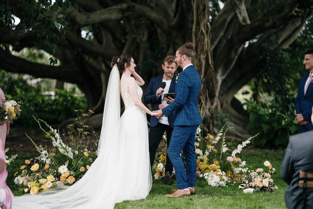 Bride and Groomtaking their vows outside under large tree