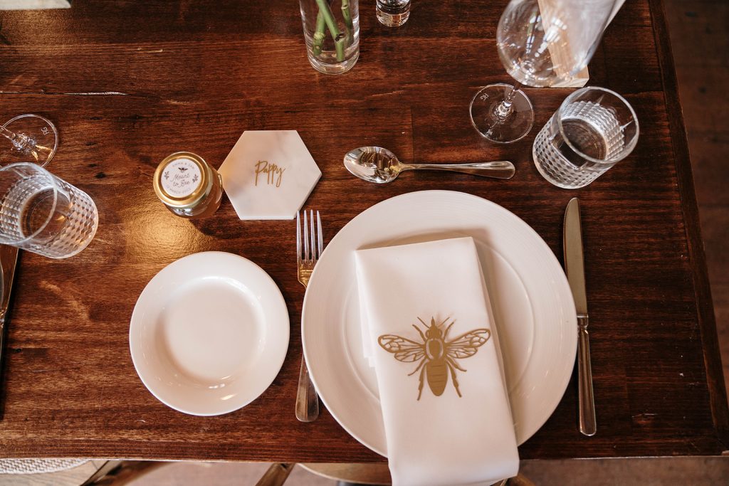 Overhead view of Gold Paper Lasercut Honey Bee Place Setting placed on white plate