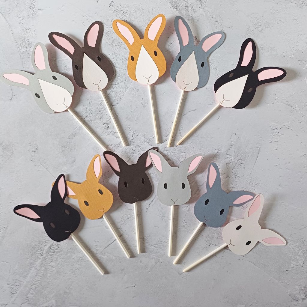 All colour variations included in the mixed set of bunny cake toppers shown. Top row: L toR pale grey, dark brown, toffee brown, dark grey, black. Rabbits have a white nose patch. Bottom row: black, toffee brown, dark brown, pale grey, dark grey, white. All the bunnies have pale pink ears, line nose and mouth details and small black eyes apart from the black rabbits which have dark brown eyes.