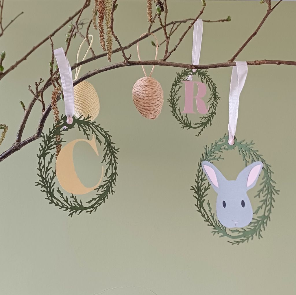 Grey Rabbit Easter Tree Hanging Decoration displayed hung from branch along with personalised initial hanging decoration and easter egg ornaments.